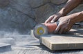 Worker hand using grinder cutting stone tile floor for paving pavement Royalty Free Stock Photo