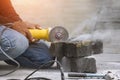 Worker hand using grinder cutting turf stone block for paving sidewalk in public area Royalty Free Stock Photo