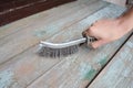 Worker hand with wire brush to strip the old paint from the wooden surface Royalty Free Stock Photo