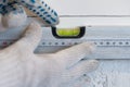 Worker hands check the evenness of the wall with a special tool for measuring the level. The stage of facing the kitchen Royalty Free Stock Photo