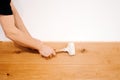 Close up of worker hands, craftsman installing wooden board of hardwood parquet using rubber hammer