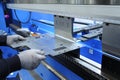 Worker hands holding the metal sheet working with the CNC hydraulic press brake machine Royalty Free Stock Photo