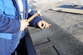 Worker hands installing bitumen roof shingles. Worker Hammer in Nails on the Roof. Royalty Free Stock Photo