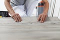 Worker hands installing timber laminate vinyl floor. Wooden floors house renovation