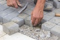 Worker hands laying concrete brick pavers 2