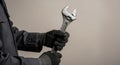 Worker Hands in Protective Gloves Holding Large Adjustable Spanner with Copy Space Royalty Free Stock Photo