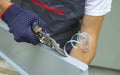 Worker hands in protective gloves preparing PVC window sill cutting metal with scissors closeup Royalty Free Stock Photo