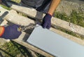 Worker hands in protective gloves preparing PVC window sill cutting metal with scissors closeup Royalty Free Stock Photo