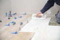 Worker hands putting tiles adhesive to the floor with the notched trowel. Royalty Free Stock Photo