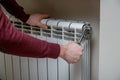 Worker hands repairing radiator with wrench.