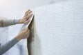 Worker hands sticking wallpaper on wall, Home decoration by yourself.
