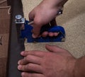 Worker hands using stapler and leather upholstering the paricle board.