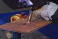 worker hands welding metal plates with semi-automatic welder at a workshop