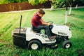 Worker, handyman trimming grass using lawn mower