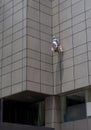 Worker hang from roof of building for maintenance out side of building under sunshine Royalty Free Stock Photo