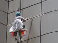 Worker hang from roof of building for maintenance out side of building under sunshine Royalty Free Stock Photo