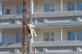 Worker hanging on ropes to painting of high buildingdin Royalty Free Stock Photo