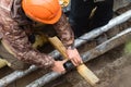 Worker in helmet repairs communal water pipe in trench on street. Work of public utilities to eliminate accident