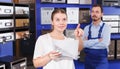 Worker helping woman choosing mailbox Royalty Free Stock Photo