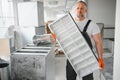 Worker holding air filter for installing in the office ventilation system. Purity of the air concept. Royalty Free Stock Photo