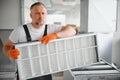 Worker holding air filter for installing in the office ventilation system. Purity of the air concept. Royalty Free Stock Photo