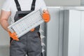 Worker holding air filter for installing in the office ventilation system. Purity of the air concept. Royalty Free Stock Photo