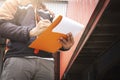 Worker Holding Clipboard is Control Loading Cargo with a Truck. Trailer Truck Parked Loading at Dock Warehouse. Logistics.