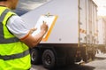 Worker holding clipboard his inspecting control load cargo freight with container trailer truck.