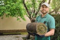 Worker holding grass sod at backyard, space for text Royalty Free Stock Photo