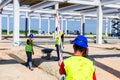 Worker is holding leveling rod to measuring level on construction site