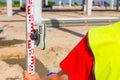 Worker is holding leveling rod to measuring level on construction site