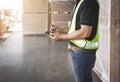Worker is Holding A Smartphone and Communicating with A Customer. Delivery Sevice. Shipment Package Boxes. Warehouse Logistics.