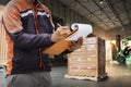 Worker Holds a Clipboard Checking the Loading Cargo Shipment at Distribution Warehouse. Forklift Tractor Loading. Shipping Trucks Royalty Free Stock Photo