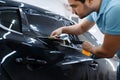 Worker holds film, car tinting installation Royalty Free Stock Photo