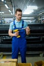 Worker holds screwdriver and bicycle hub, factory Royalty Free Stock Photo