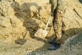 worker holds a shovel with sand