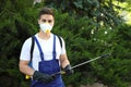 Worker with insecticide sprayer near green bush. Pest control Royalty Free Stock Photo