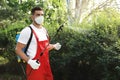 Worker with insecticide sprayer near green bush. Pest control Royalty Free Stock Photo