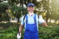 Worker with insecticide sprayer near green bush outdoors. Pest control Royalty Free Stock Photo