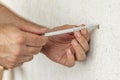 Worker inserts plastic wall plug into a hole.