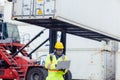 Worker inspect relay checking information data logistics on a tablet computer in a dock shipping. Business logistic concept,