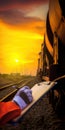 Worker inspecting freight train at sunset on railway Royalty Free Stock Photo