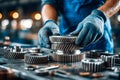 Worker inspecting precision gears in an industrial manufacturing setting Royalty Free Stock Photo