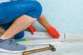 Worker instal plastic skirting board on laminate flooring. Renovation of baseboard at home. Royalty Free Stock Photo