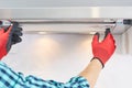 Worker install filter in home range hood at kitchen. Handyman removing filter from a exhaust hood. Cooker hood repair Royalty Free Stock Photo