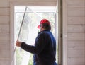 Worker install mosquito net or mosquito wire screen on wooden house window. Royalty Free Stock Photo