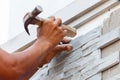 Worker install stone wall surface with cement for house