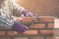 Worker installing bricks wall in process of house building Royalty Free Stock Photo