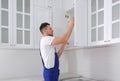 Worker installing cabinet with shelves Royalty Free Stock Photo