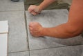 Worker installing ceramic tile on the floor, bathroom flooring Royalty Free Stock Photo